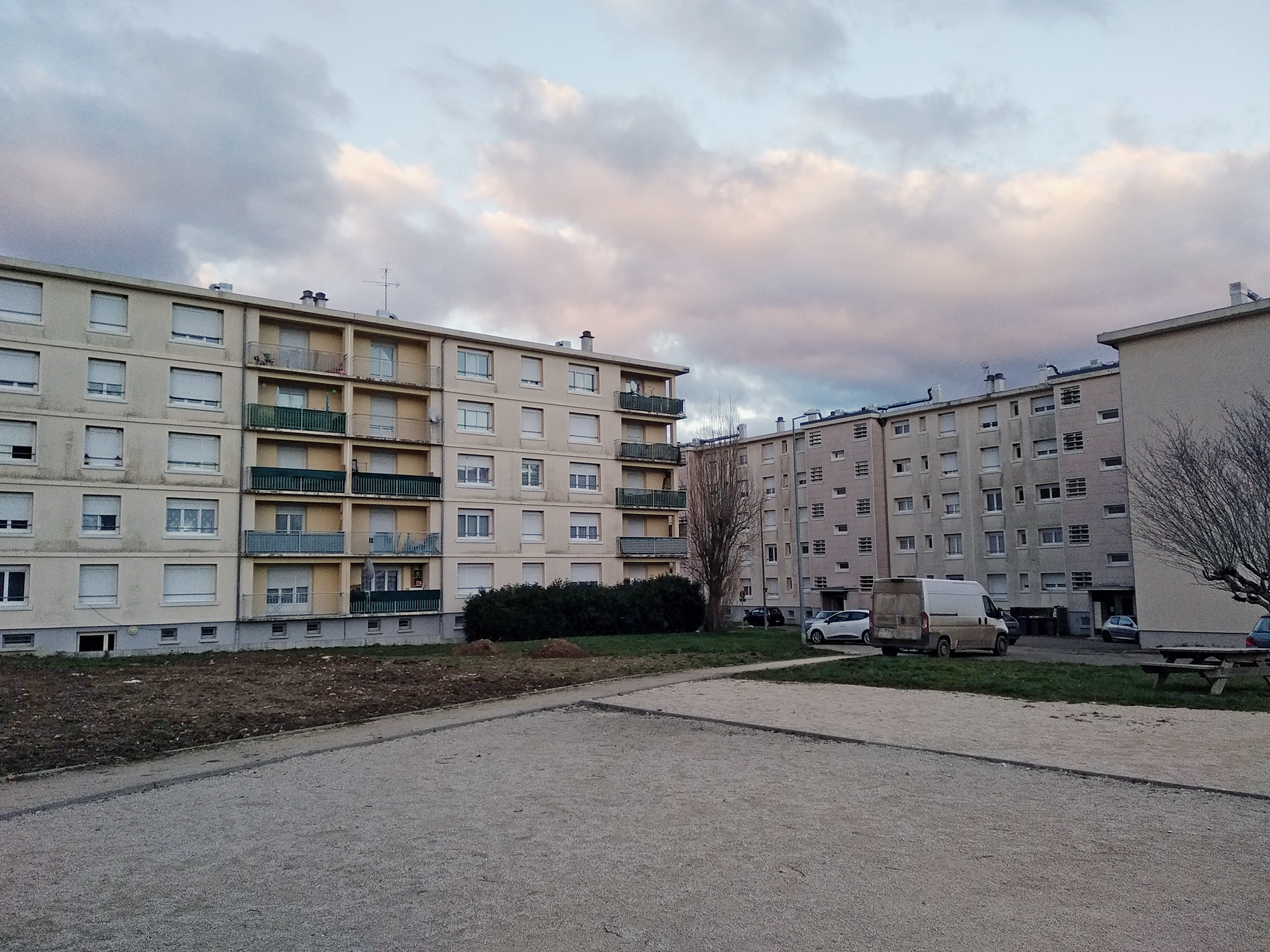The La Morlande residential district in Avallon, with apartment blocks, open courtyard space, and evening clouds.